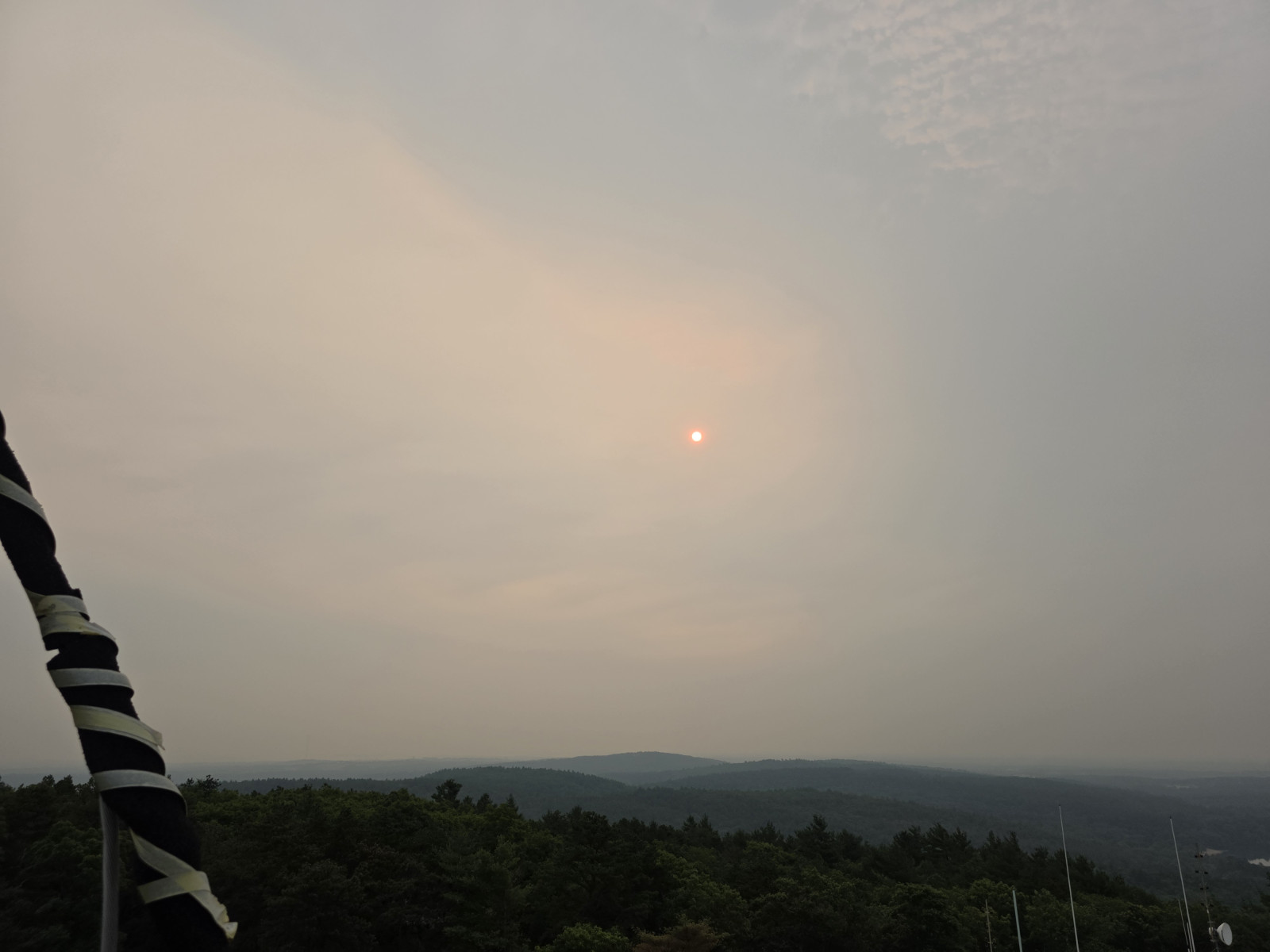 The hazy red sun over Blue Hill Observatory's summit instruments on the morning of July 15, 2026