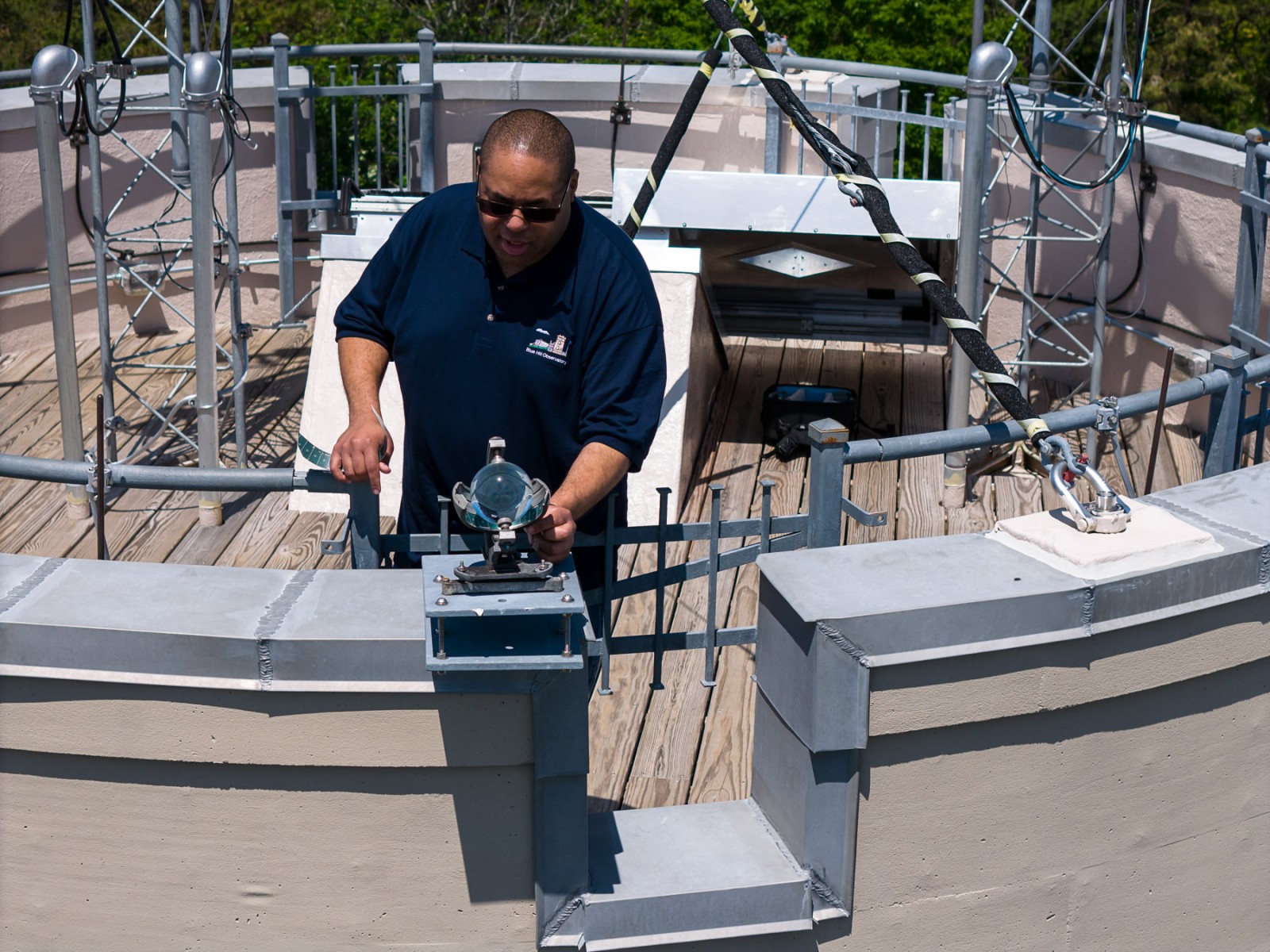 A Blue Hill Observatory weather observer working with instruments on the rooftop observation deck