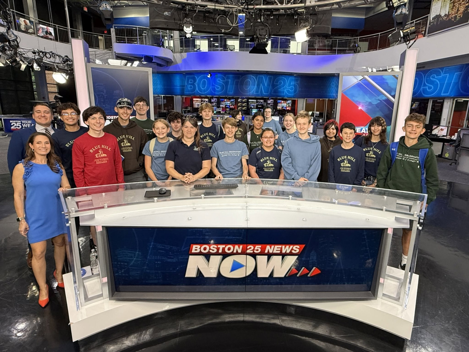 LYMC students and staff posing at the Boston 25 News anchor desk